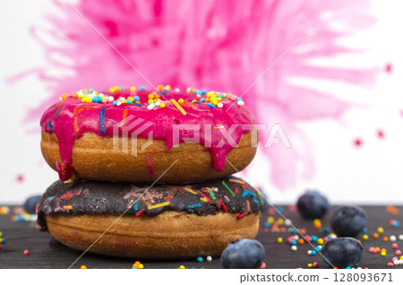 Creative sweet food. Bright donuts with multi-colored sprinkles on a colorful background. Creative sweet food. Bright donuts with multi-colored sprinkles on a colorful background. 128093671
