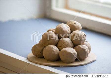 Pieces of clay balls on a plate. 128093833