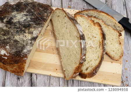 Sliced rustic homemade bread on wooden board Sliced rustic homemade bread on wooden board 128094938