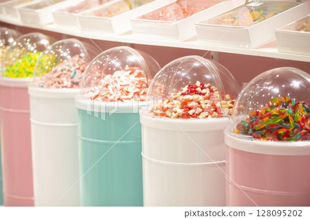 Jelly candies in containers in a store. Large selection of sweets in different colors. Sale of sweets. 128095202