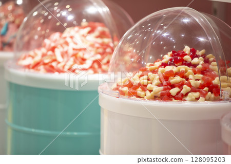 Jelly candies in containers in a store. Large selection of sweets in different colors. Sale of sweets. Jelly candies in containers in a store. Large selection of sweets in different colors. Sale of sweets. 128095203
