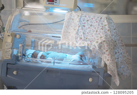 Newborn baby in the medical box at the hospital.Closeup of an infant incubator technology in a medical center hospital 128095205