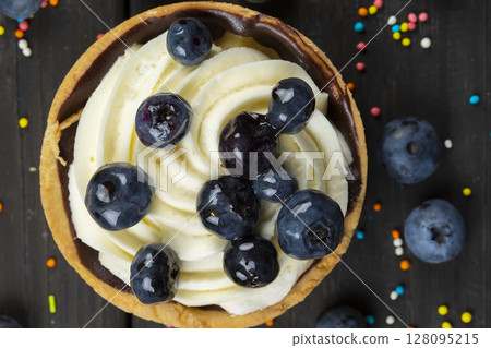 Nice food. Small cake with cream and berries on a dark background. 128095215