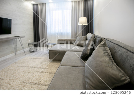 Part of the room with a sofa in beige tones. 128095246