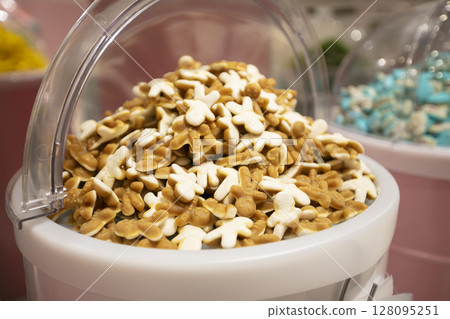 Jelly candies in containers in a store. Large selection of sweets in different colors. Sale of sweets. 128095251