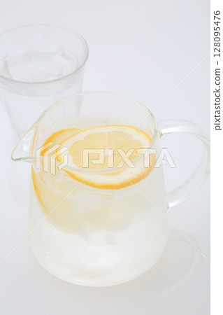 Meyer lemon cut into pieces and a pitcher of lemon water Meyer lemon cut into pieces and a pitcher of lemon water 128095476