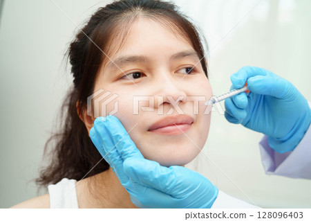 Asian woman receiving lip contouring procedure augmentation performed on face. 128096403