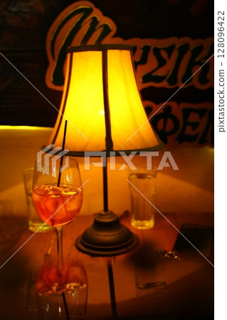 Cozy Evening with Wine Glass and Warm Lamp Glow Cozy Evening with Wine Glass and Warm Lamp Glow 128096422