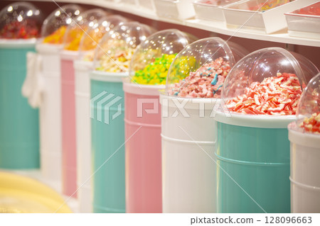 Jelly candies in containers in a store. Large selection of sweets in different colors. Sale of sweets. 128096663