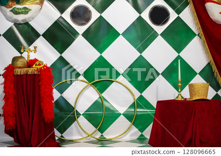 Circus background with various circus objects. Stage of the Circus Theater. Bright circus decorations with hats, feathers and gold hoops. Circus background with various circus objects. Stage of the Circus Theater. Bright circus decorations with hats, feathers and gold hoops. 128096665