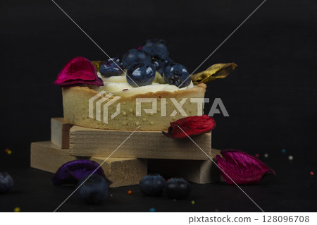 A beautiful cake with blueberries on a dark wooden background. A beautiful cake with blueberries on a dark wooden background. 128096708