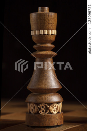 Chess queen on a black background. A puzzle game with tricky combinations that requires planning and thinking. 128096721