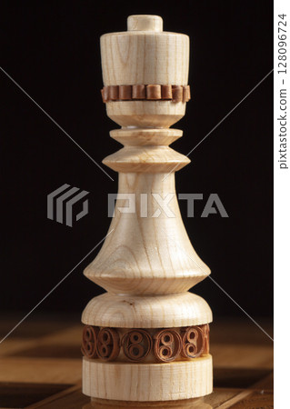 Chess queen on a black background. A puzzle game with tricky combinations that requires planning and thinking. Chess queen on a black background. A puzzle game with tricky combinations that requires planning and thinking. 128096724
