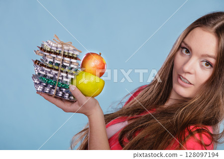Woman holding pills and fruits. Health care 128097194