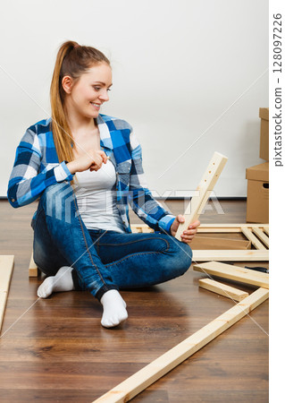 Woman assembling wooden furniture. DIY. Woman assembling wooden furniture. DIY. 128097226