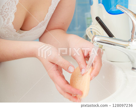 Woman washing hands under flowing tap water Woman washing hands under flowing tap water 128097236