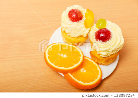 Gourmet cream cake cookie and orange on plate Gourmet cream cake cookie and orange on plate 128097254