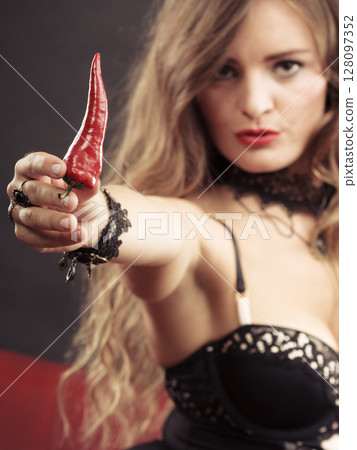 Woman wearing lingerie holding chilli pepper 128097352