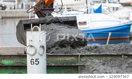 Excavator shovel digging in sand from water Excavator shovel digging in sand from water 128097367