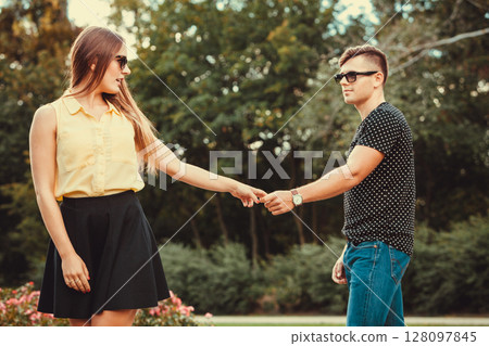 Cheerful girl holding hands in park. 128097845