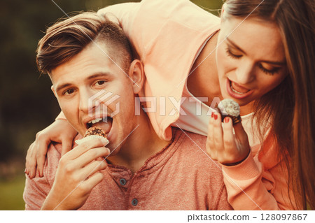 Lovely couple eating cupcakes. 128097867