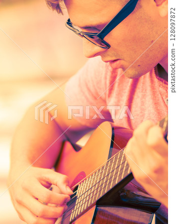 Trendy guy with guitar outdoor Trendy guy with guitar outdoor 128097872