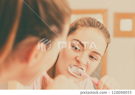 Woman brushing cleaning teeth in bathroom Woman brushing cleaning teeth in bathroom 128098055