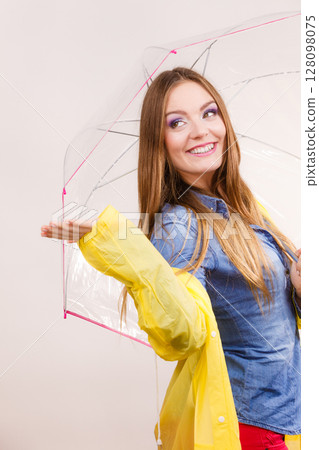 Woman in rainproof coat with umbrella. Forecasting 128098075