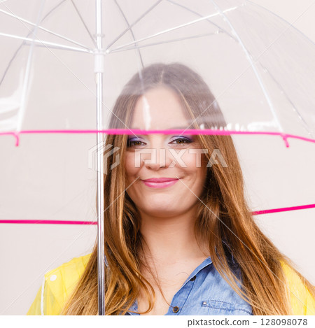 Woman wearing waterproof coat under umbrella Woman wearing waterproof coat under umbrella 128098078
