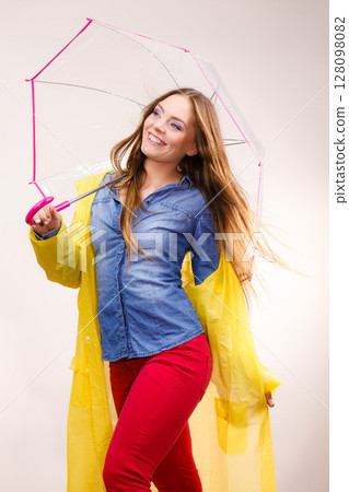 Woman wearing waterproof coat under umbrella Woman wearing waterproof coat under umbrella 128098082