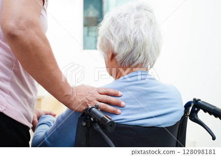 Caregiver help Asian elderly woman disability patient sitting on wheelchair in hospital. 128098181