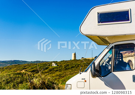 Caravan on spanish coast, lighthouse in distance 128098315