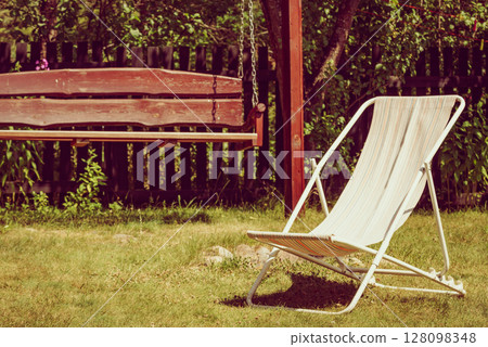 Garden with deck chair and swing 128098348