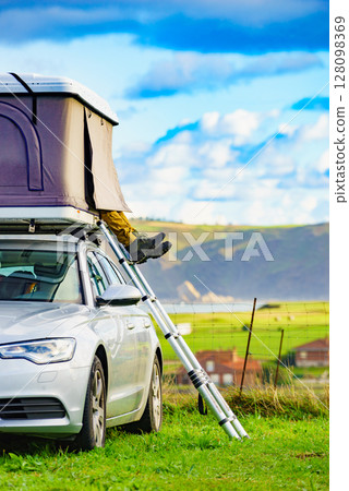 Car with roof top tent camp on sea shore 128098369