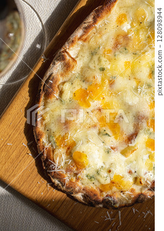 Four cheese pinsa on wooden board Four cheese pinsa on wooden board 128098944