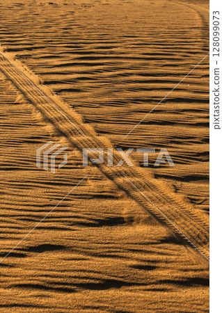 Tire mark on the sand after the car. Texture after car's wheel Tire mark on the sand after the car. Texture after car's wheel 128099073