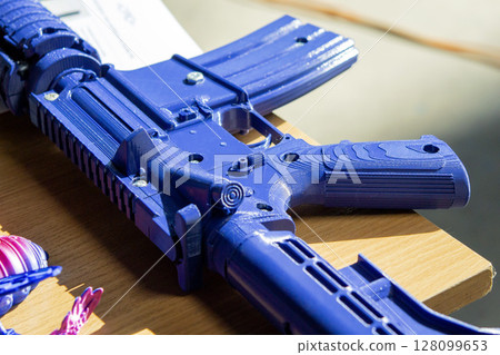 Machine gun printed on a 3D printer. Model prototype of the machine gun created on a 3D printer from molten plastic. Modern new additive progressive 3d printing technologies. 3d printing technology Machine gun printed on a 3D printer. Model prototype of the machine gun created on a 3D printer from molten plastic. Modern new additive progressive 3d printing technologies. 3d printing technology 128099653