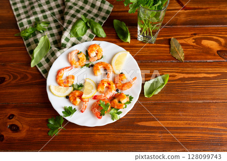 Appetizing seafood in a plate on a wooden, with lemon and herbs 128099743