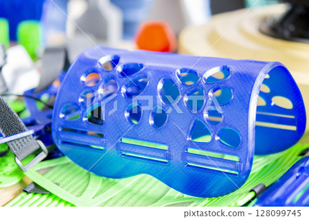 Medical splint for hand treatment. Medical splint printed on 3D printer from molten plastic. Model created on 3D printer. Modern additive progressive 3d printing technologies. 3D printing technology Medical splint for hand treatment. Medical splint printed on 3D printer from molten plastic. Model created on 3D printer. Modern additive progressive 3d printing technologies. 3D printing technology 128099745