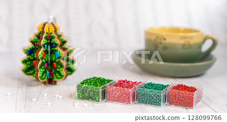 Colorful glass beads with christmas tree. Variety of shapes and colors to make a bead necklace or a string of beads for women Colorful glass beads with christmas tree. Variety of shapes and colors to make a bead necklace or a string of beads for women 128099766