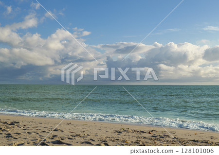 Sandy beach in Nokomis Florida with turquoise Gulf of Mexico under bright cloud sky Sandy beach in Nokomis Florida with turquoise Gulf of Mexico under bright cloud sky 128101006