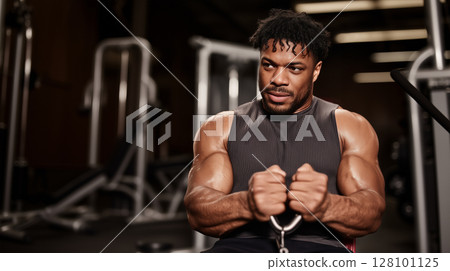 Portrait of a black man exercising on deadlift machine while sitting in gym, copy space about sport and active life concept 128101125