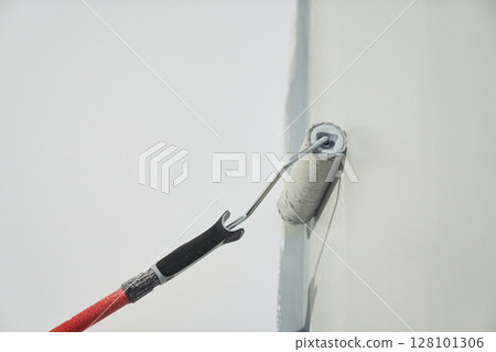 Roller painting of the wall, working painting on the surface, painting the walls in the apartment, repair with white paint. With space to copy. High quality photo 128101306