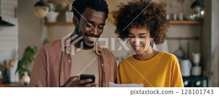 Happy couple reviewing bills and finances at home 128101743