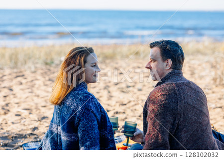 Portrait happy beautiful couple in love enjoying autumn picnic in autumn park. Back view. High quality photo Portrait happy beautiful couple in love enjoying autumn picnic in autumn park. Back view. High quality photo 128102032