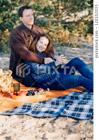 Portrait happy beautiful couple in love enjoying autumn picnic in autumn park. Vertical photo. High quality photo Portrait happy beautiful couple in love enjoying autumn picnic in autumn park. Vertical photo. High quality photo 128102033