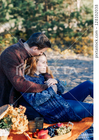 Portrait happy beautiful couple in love enjoying autumn picnic in autumn park. Vertical photo. High quality photo 128102038