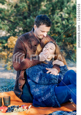 Portrait happy beautiful couple in love enjoying autumn picnic in autumn park. Vertical photo. High quality photo Portrait happy beautiful couple in love enjoying autumn picnic in autumn park. Vertical photo. High quality photo 128102058