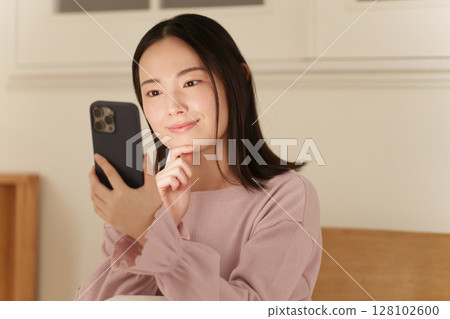 A woman looking at her smartphone in the middle of the night A woman looking at her smartphone in the middle of the night 128102600