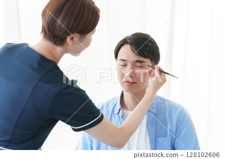 一位男士正在接受美容顧問的修眉服務 128102606
